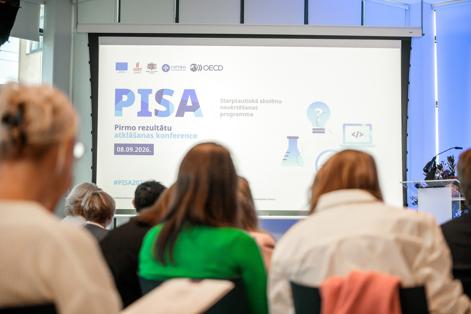 PISA 2025 pirmo rezultātu atklāšanas konferences dalībnieki skatās prezentāciju.