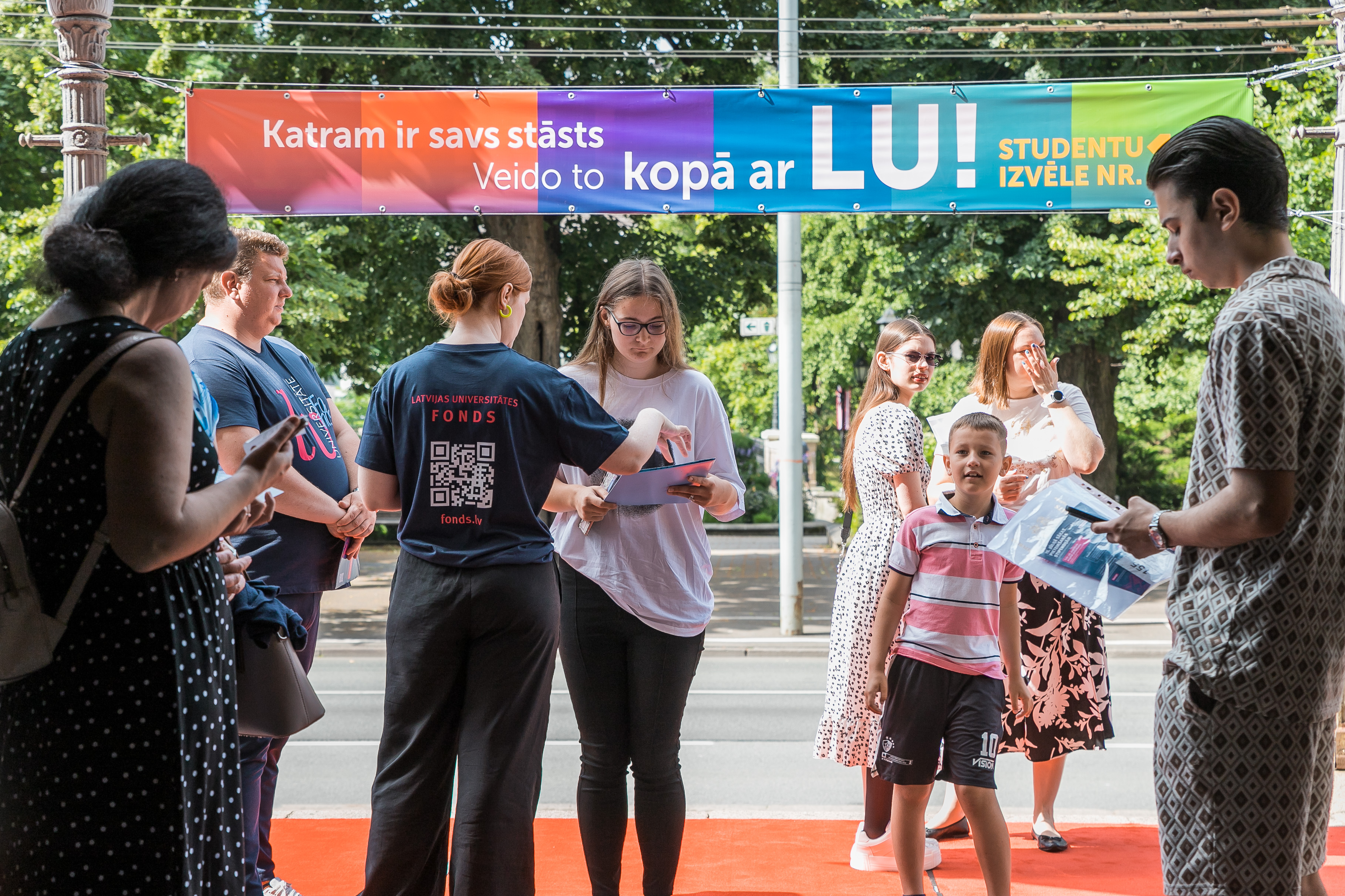 Cilvēki sapulcējušies pie ieejas Latvijas Universitātes ēkā