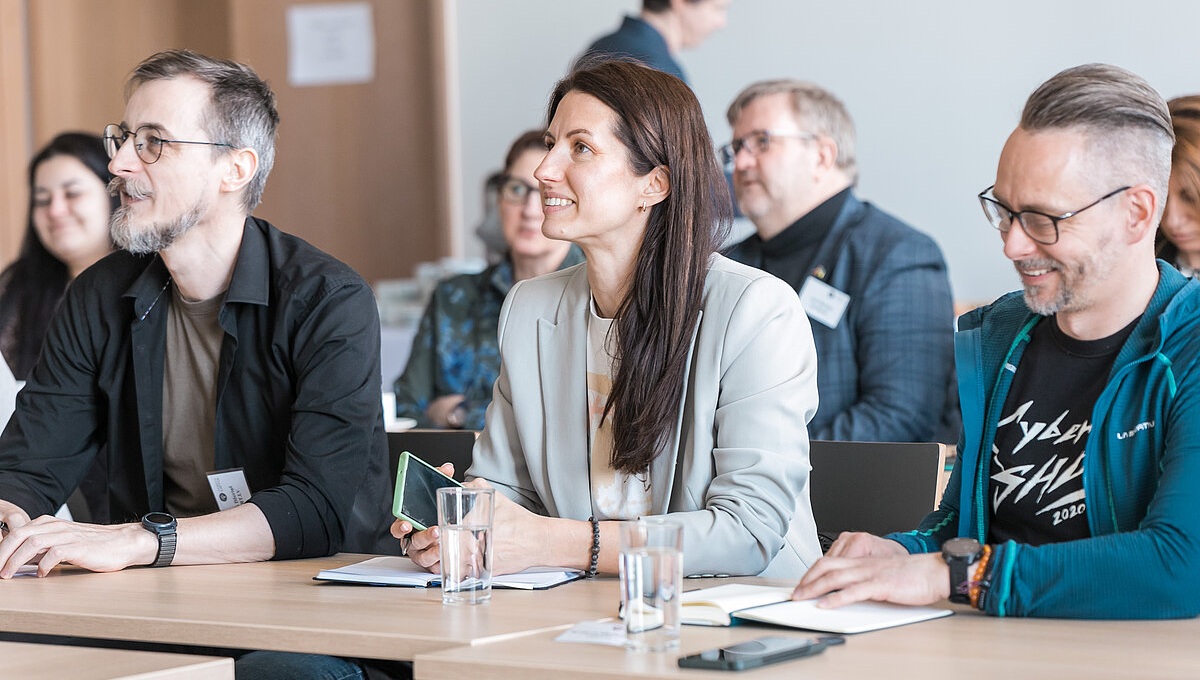 Cilvēki sēž pie galda seminārā