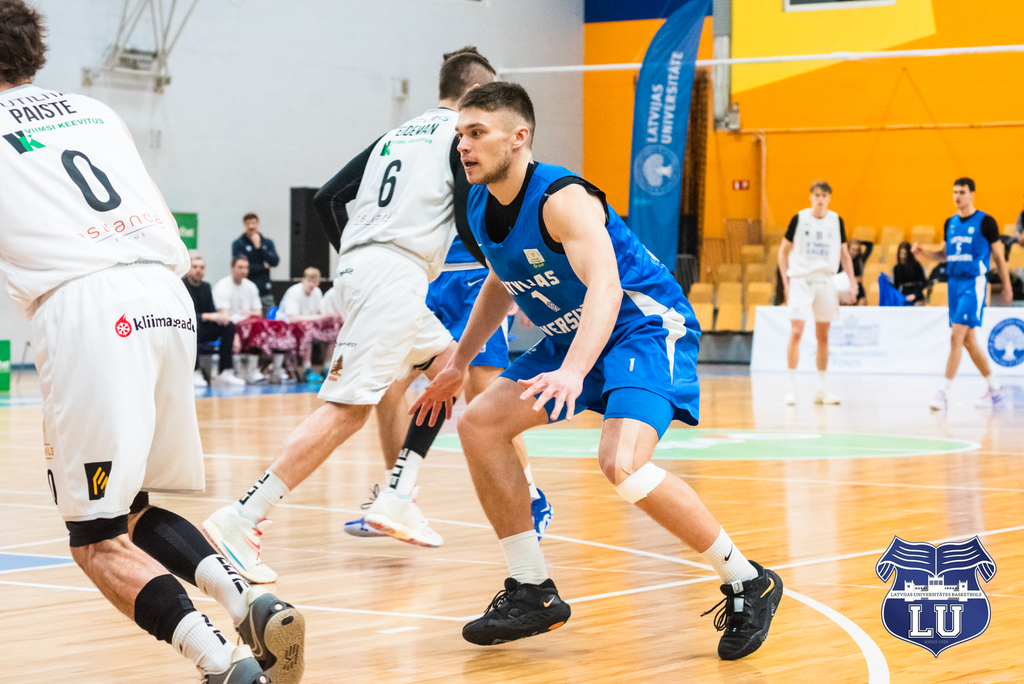Lu basketbolists uz laukuma spēles laikā, otras komandas pārstāvji