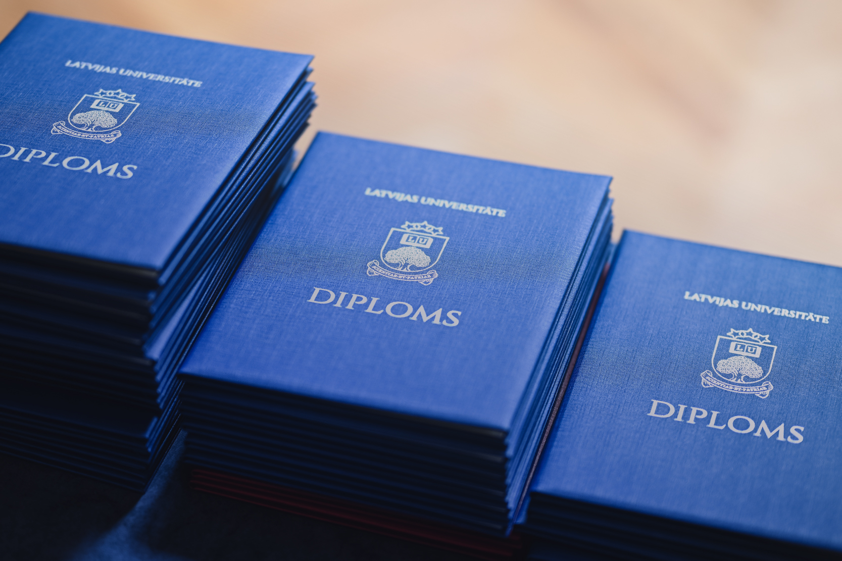 Latvijas Universitātes diplomu kaudzītes novietotas uz galda pirms izlaiduma ceremonijas.
