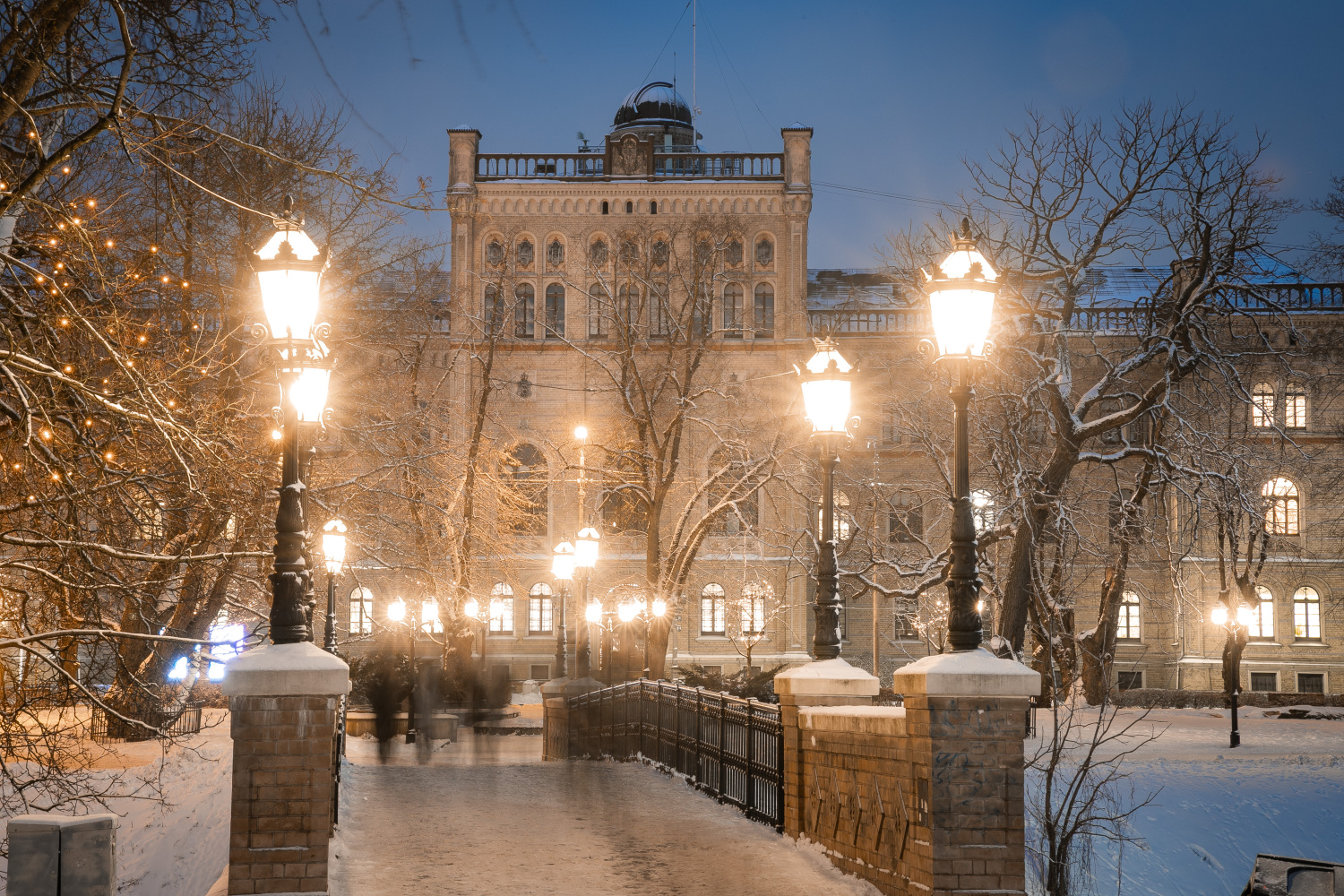 LU ēka ziemā, apkārt sniegs un ļoti skaistas gaismiņas un gaismas dekori